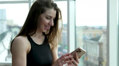 Spor salonunda akıllı telefon kullanan genç bir kız. Jimnastik kız telefonu.