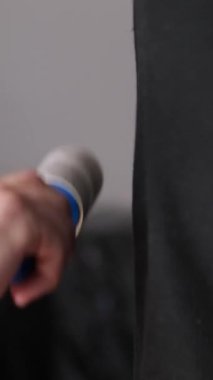 Tişörtten tüy ve yünü pamuklu bir rulo ile çıkarıyor. Kıllı silindir tutan bir adam. Temiz giysi silindiri