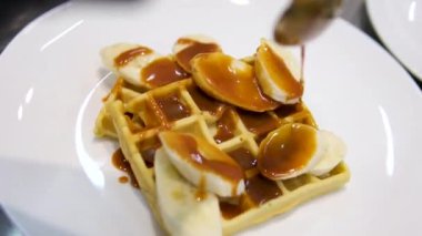 Elektrikli waffle makinesinde ev yapımı waffle yapmak. Kahvaltı şefi unu karıştırıyor, yumurta çırpıyor waffle yapmak için hamur pişiriyor, krep yapıyor. Sabah kahvaltısı, yemek hazırlama, yemek tarifi...