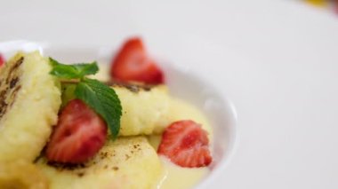 Kızarmış peynirli kekler aşama aşama pişiriliyor. Eller kaymak toplarını yuvarlar. Peynirli kekler tavada kızartılır. Lezzetli yemekler hazırlama süreci. Cheesecake veya cheesecake. Sağlıklı yemek.