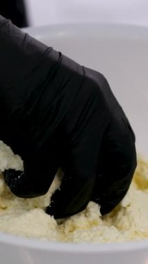 Kızarmış peynirli kekler aşama aşama pişiriliyor. Eller kaymak toplarını yuvarlar. Peynirli kekler tavada kızartılır. Lezzetli yemekler hazırlama süreci. Cheesecake veya cheesecake. Sağlıklı yemek.