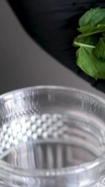 Naneli ve limonlu bir içki hazırla. Limonata, yaz içeceği, soğuk içecek, sağlıklı sıvı Mojito kokteyli. Bir bardak alkollü kokteyl, rom, limon, nane, kırık buz.