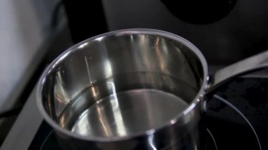 Su banyosu için metal kepçe masanın üzerinde duruyor. Paslanmaz çelik kepçeyle su kaynatılır ve yumurta pişirilir.