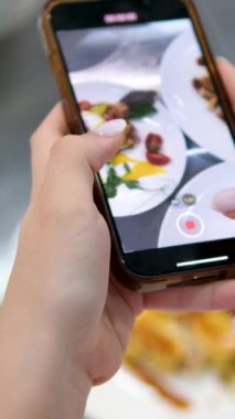  Kahvaltı için telefonundan video blogu çek, haşlanmış yumurta Benedict, cheesecake ve waffle. Gıda Blogçusu