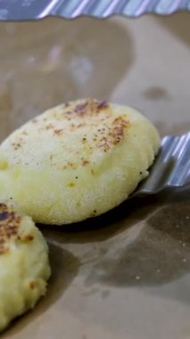 Kızarmış peynirli kekler aşama aşama pişiriliyor. Eller kaymak toplarını yuvarlar. Peynirli kekler tavada kızartılır. Lezzetli yemekler hazırlama süreci. Cheesecake veya cheesecake. Sağlıklı yemek.
