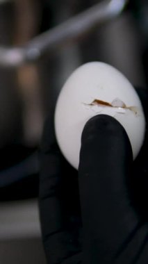 Haşlanmış yumurta kaynatın. Bir tencerede kaynayan suda haşlanmış yumurta. Yakın plan. Haşlanmış yumurta bir tencerede kaynatılır. Kavrulmuş bir yumurta ocakta düşük ısıda sıcak suda kaynatılır..