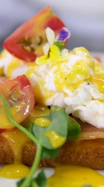 Sağlıklı sabah yemeği. Kahvaltıda lezzetli haşlanmış yumurta yemek. Erkek elleri, yumurtanın içinde yumurta sarısı, hollandaise sosu ve İngiliz çöreğine ıspanak olan Benedict yumurtalarını keser. Kapat.