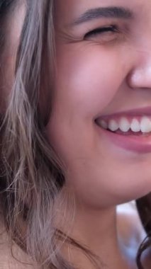 Gülümseyen genç kadın ya da kadın kameraya bakıp mutlu ve neşeli hissediyordu. Doğal olarak siyah tişörtlü kız beyaz arka planda izole edilmiş. Yakın plan. Güzel dişli kadın gülümsüyor