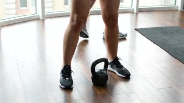 Egzersiz, kadın ve erkek kettlebell, fitness ve sağlık, sağlık ve beden eğitimi. Sağlıklı bir çift, spor aletleri ve esneme, rutin çalışma ve spor kıyafetlerine odaklanma..
