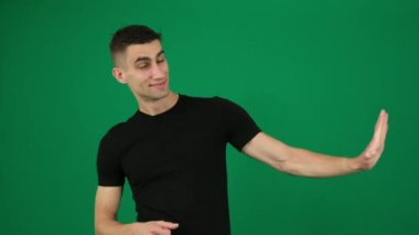 Yeşil atölye işaretleriyle poz veren iyimser mizahi Arap portresi tabanca kullanıyormuş gibi davranmak, iyi fikir reklamlarını onaylatmaya yarıyor. ürün