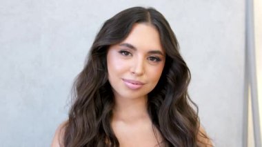 Güzel Kadın Stüdyosu. Mükemmel ciltli, mükemmel makyajlı, dalgalı saçlı güzel bir genç kız. Cilt bakım ürünleri reklamı. Doğal güzellik. ProRes kodlayıcısı