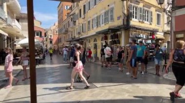 Turistleri. Güneşli bir günde sokak Korfu adasında yürüyen insanlar 07.02.2024