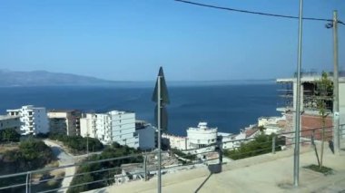 Arnavutluk dağları. Arnavutluk 'ta dağ zirvelerinde bulutlar dolaşıyor. Sürücü arabaların penceresinden görüntüler