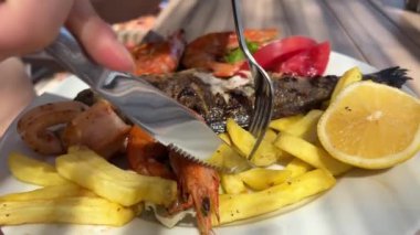 Arnavutluk 'ta bir restoranın sokağında Dorado balığı, patates kızartması ve karides. Restoranda Dorado balığı. Sebze soslu fırında dorado balığı ve ızgara sebze.