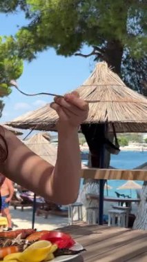Bir kız sahilde balık yiyerek mutlu olur. İtalya 'daki Vernazza köyünün güzel manzaralı deniz ürünleri tabağı taşıyan bir kadın. Akdeniz yemekleri konsepti. Seyahat fikri