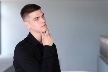 Süveterli, şoke olmuş, ağzı açık, inançsız genç bir İspanyol. Korkmuş, şaşırmış bir yüz, beyaz arka planda tek başına duruyor. Şaşkınlık sürprizi