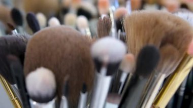 Ressam resim çizmeden önce fırçaları ve palet bıçakları inceliyor. Fırça seçen tanınmamış genç bir sanatçı. Sanat eserleri. Resim yapmak için araçlar. 