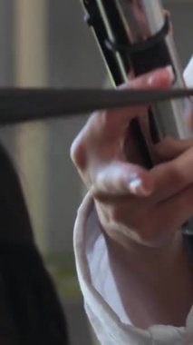 Makyajlı, tüvit ceketli, beyaz arka planda kameranın önünde göz farı sürerken poz veren şık bir kadın. Göz farını uygula