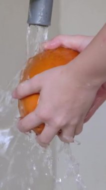 Papaya yıka. Suyun altında meyve yıka.