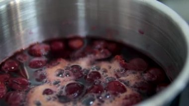 Kiraz reçeli yapmak için taze toplanmış kırmızı kirazlı şekerin hazırlanması, yakın plan, üst manzara. Tencerede ev yapımı kirazlı meyve reçeli pişirmek. Kiraz kaynat.