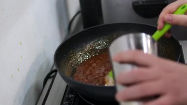 Aşçı sıcak bir tavada beyaz şekeri karıştırdı. Şeker erir ve karamelize olur. Evde tatlı pişirme süreci. Kızartma tavasında karamel