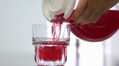 Bir sürahide kırmızı içecek dolduruyorum. Kırmızı çilekli doğal meyve suyu, pembe neonlu şeffaf sürahide cam bardaktan akıyor..