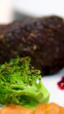 Sığır filetosu bifteği hazırlama işlemi. Yavaş çekimde dumanlı tavada baharatlı ve otlu sulu et bifteği yakın çekim. Meyveli biftek piknik kutlaması için hazır. Barbekü