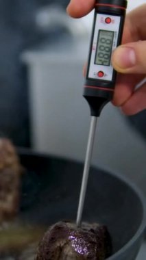 Sığır filetosu bifteği hazırlama işlemi. Yavaş çekimde dumanlı tavada baharatlı ve otlu sulu et bifteği yakın çekim. Meyveli biftek piknik kutlaması için hazır. Barbekü