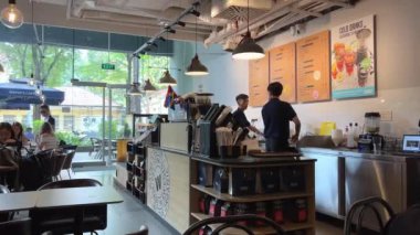 Kahve dükkanı çalışanları Waves Coffee 'de dizüstü bilgisayarlar üzerinde çalışıyor. Üçüncü Dalga Kahve Dükkanı Vietnam Ho Chi Minh Şehri 07.18.2024