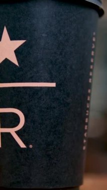 Starbucks Resort siyah Starbucks bardağı. Kahve dükkanının masasında üzerinde büyük harfli R harfi var. Lezzetli, yeni, lüks kahve markası. en yeni