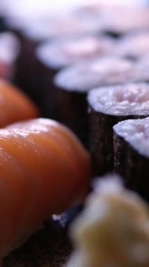 Pirinçli Japon yemeği, kırmızı çiğ balık, krem peynir, somon, karides, avokado ve nori. Masada dürümler olan iştah açıcı suşi seti. Bir suşi şefinden inanılmaz lezzetli ve pahalı yemekler. Suşi takımı.