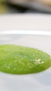  Yeşil sebze püresi beyaz tabakta izole edilmiş. en üstteki görünüm