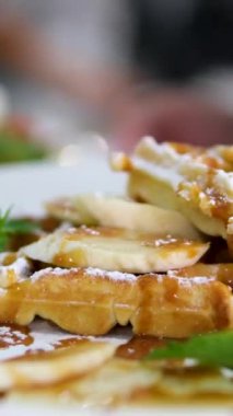 Garson naneli ve muzlu waffle ve domatesli salata getiriyor..