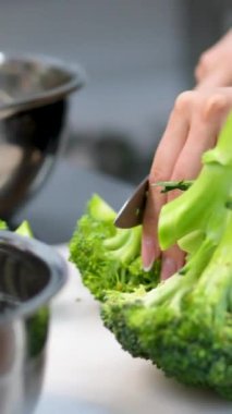 Brokoli kesiyorum. Brokoli pişirmek için hazırlanıyor. Kesme tahtasında brokoli kabağı kesmek. Karnabahar doğrama