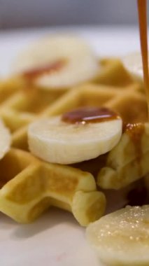 Belçika wafflelarının üzerine bal ya da akçaağaç şurubu dökerek. Waffle 'ların üzerine karamel dök