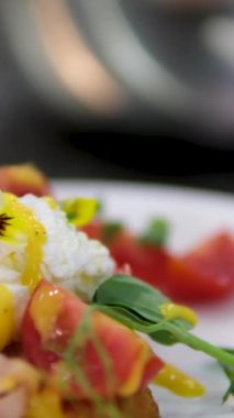 Benedict usulü yumurta. Yumurtalı sandviçin üzerinde yenilebilir çiçekler, haşlanmış yumurtalar, üzerine sos serpiştirilmiş Benedict.