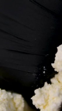 Aşçı süzme peyniri yumurta ve şekerle karıştırır. Şef hamuru hazırlar. Şef cheesecake hazırlıyor. Eller hamuru demir bir tabakta karıştırır. Süzme peyniri ellerinle karıştır