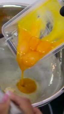 Hollandaise soslu Benedict usulü yumurta. Hollandaise sosunu metal bir kaşıkla güveçte harmanlamak.