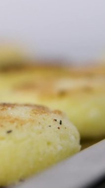 Eldivenli bir kadın, peynirli krep ve şerbet döker. Fırın tepsisindeki peynirli kekler. Fırın tepsisindeki süzme peynirli krepler.