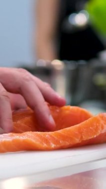 Erkek şef balık fileto bıçağı kullanıyor restoranda tahtanın üzerinde taze somon eti dilimliyor, Şef müşteriye sağlıklı menü somon balığı ya da suşi hazırlıyor, Japon mutfağı tarifleri..