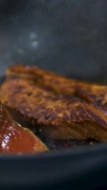 Somon bifteği yakın planda kızartma tavasında pişirilir. Sağlıklı beslenme için kırmızı alabalık balığı. Kızartma tavasında kızarmış somon.