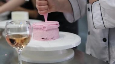 Şekerlemeler, pişirme ve pişirme konsepti. Evdeki mutfakta pasta yapan kadın. Bento keki yapma süreci. Elinde kremalı ahudududulu kek tutan kadın.
