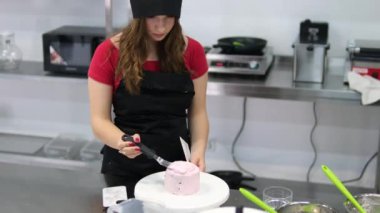Şekerlemeler, pişirme ve pişirme konsepti. Evdeki mutfakta pasta yapan kadın. Bento keki yapma süreci. Elinde kremalı ahudududulu kek tutan kadın.