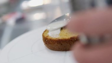 Şekerlemeler, pişirme ve pişirme konsepti. Evdeki mutfakta pasta yapan kadın. Bento keki yapma süreci. Elinde kremalı ahudududulu kek tutan kadın.