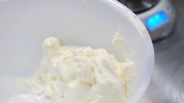 Şekerlemeler, pişirme ve pişirme konsepti. Evdeki mutfakta pasta yapan kadın. Bento keki yapma süreci. Elinde kremalı ahudududulu kek tutan kadın.