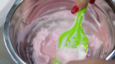 Şekerlemeler, pişirme ve pişirme konsepti. Evdeki mutfakta pasta yapan kadın. Bento keki yapma süreci. Elinde kremalı ahudududulu kek tutan kadın.