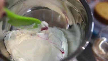 Şekerlemeler, pişirme ve pişirme konsepti. Evdeki mutfakta pasta yapan kadın. Bento keki yapma süreci. Elinde kremalı ahudududulu kek tutan kadın.