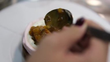 Şekerlemeler, pişirme ve pişirme konsepti. Evdeki mutfakta pasta yapan kadın. Bento keki yapma süreci. Elinde kremalı ahudududulu kek tutan kadın.
