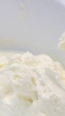 Şekerlemeler, pişirme ve pişirme konsepti. Evdeki mutfakta pasta yapan kadın. Bento keki yapma süreci. Elinde kremalı ahudududulu kek tutan kadın.