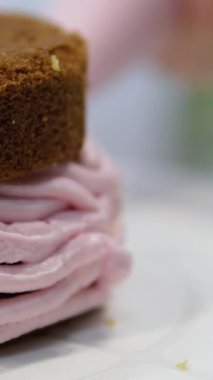 Şekerlemeler, pişirme ve pişirme konsepti. Evdeki mutfakta pasta yapan kadın. Bento keki yapma süreci. Elinde kremalı ahudududulu kek tutan kadın.